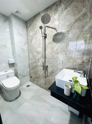 a bathroom with a toilet and a sink and a shower at Llanes A Studio Apartment in Manila