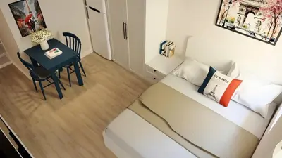 a small room with a bed and a table at Llanes A Studio Apartment in Manila