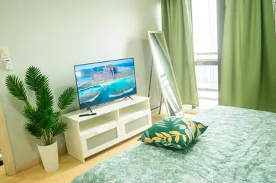 a bedroom with a bed and a television on a dresser at Nature Serenity Suites 2BR Makati in Manila