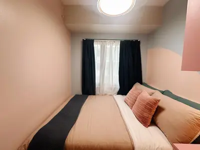 a small bedroom with a bed with a window at The Ritz Place at Shore 3 Residences in Manila