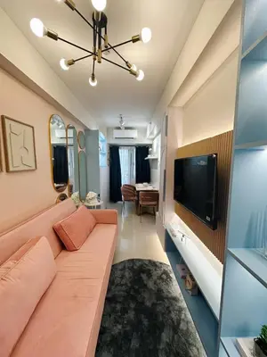 a living room with a couch and a tv at The Ritz Place at Shore 3 Residences in Manila