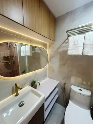 a bathroom with a sink and a toilet and a mirror at The Ritz Place at Shore 3 Residences in Manila