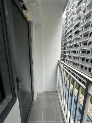 a balcony with a glass door in a building at The Ritz Place at Shore 3 Residences in Manila