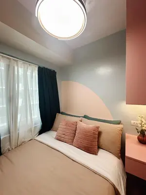 a bedroom with a bed with two pillows on it at The Ritz Place at Shore 3 Residences in Manila