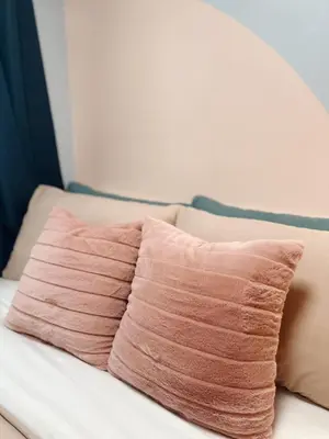 a pink pillow sitting on top of a couch at The Ritz Place at Shore 3 Residences in Manila