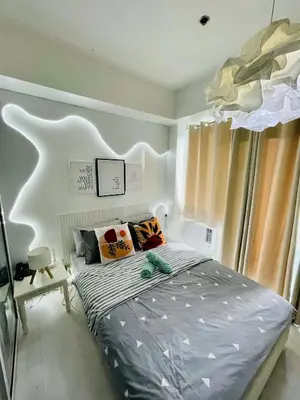 a bedroom with a large bed with pillows on it at Azure Rio East 221 in Manila