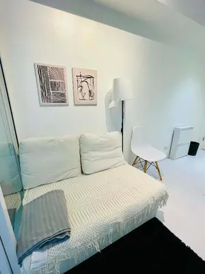 a white room with a bed and a chair at Azure Rio East 221 in Manila