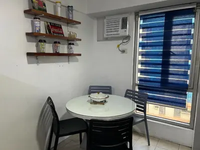 a table and chairs in a room with a window at Ports Avida San Lazaro Condo in Manila