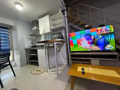 a living room with a large flat screen tv on a wall at Ports Avida San Lazaro Condo in Manila