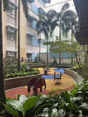 a park with a statue of a bear in front of a building at Vienna Condotel in Manila