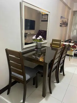 a dining room table with two chairs and a mirror at Vienna Condotel in Manila