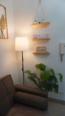 a living room with a couch and a lamp and a plant at Shore 2 Residences in Manila