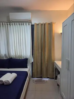 a bedroom with a bed with blue sheets and curtains at Shore 2 Residences in Manila