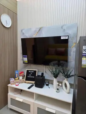 a room with a desk with a clock and a tv at Shore 2 Residences in Manila