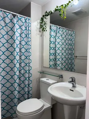 a bathroom with a toilet and a sink and a mirror at The Session Azure in Manila