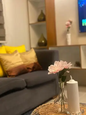 a vase with a flower on a table in a living room at Apartment in MOA Pasay City Homey Luxury in Manila