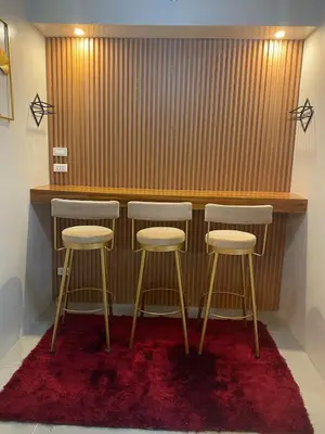 a bar with three stools in front of a counter at Apartment in MOA Pasay City Homey Luxury in Manila