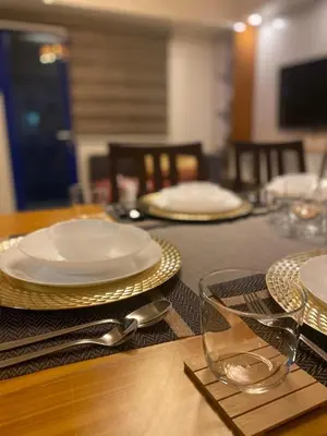 a table with plates and silverware on top of it at Apartment in MOA Pasay City Homey Luxury in Manila