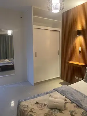 a bedroom with a bed and a door with a mirror at Apartment in MOA Pasay City Homey Luxury in Manila