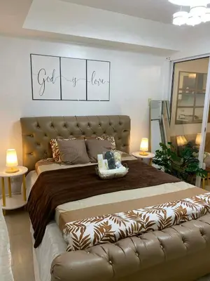 a bedroom with a large bed with a leather headboard at Azure Staycation in Manila