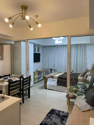 a large living room with a bed and a kitchen at Azure Staycation in Manila