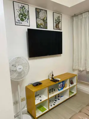 a living room with a flat screen tv and a fan at Azure Staycation in Manila