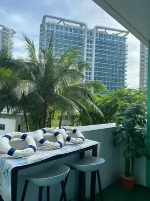a table with chaise lounges and beach balls on a balcony at Azure Staycation in Manila