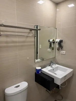 a bathroom with a sink and a toilet and a mirror at Venice Luxe Cozy 1 BedRoom, Pool, Netflix, Kitchen, Canal Mall Access in Manila