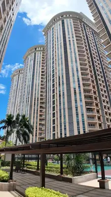 a large building with palm trees in front of it at Venice Luxe Cozy 1 BedRoom, Pool, Netflix, Kitchen, Canal Mall Access in Manila