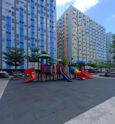a playground in a park with buildings in the background at 2BR DECA HOME Pasig City in Manila