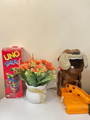a table with a vase of flowers and a box of uno skate at 2BR DECA HOME Pasig City in Manila