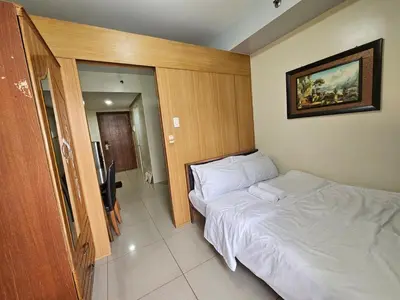a bedroom with a white bed and a picture on the wall at Shell Low Floor Amenity Pool View with Balcony MOA Shell004 in Manila