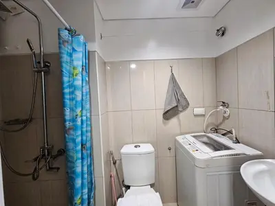 a bathroom with a shower and a toilet and a sink at Shell Low Floor Amenity Pool View with Balcony MOA Shell004 in Manila