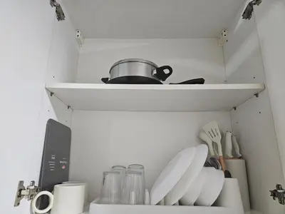 a kitchen shelf with plates and utensils on it at Shell Low Floor Amenity Pool View with Balcony MOA Shell004 in Manila
