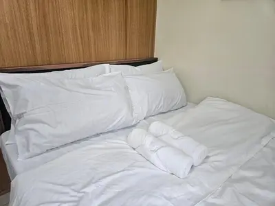 a white bed with white sheets and pillows at Shell Low Floor Amenity Pool View with Balcony MOA Shell004 in Manila