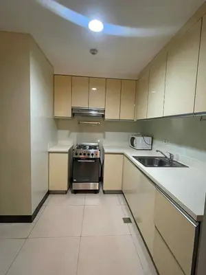 a small kitchen with a stove and a sink at 2 Bedroom at The infinity Condominium at BGC in Manila