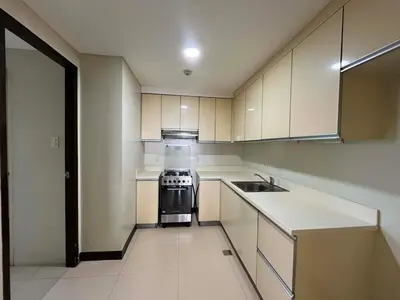 a kitchen with white cabinets and a stove and a sink at 2 Bedroom at The infinity Condominium at BGC in Manila