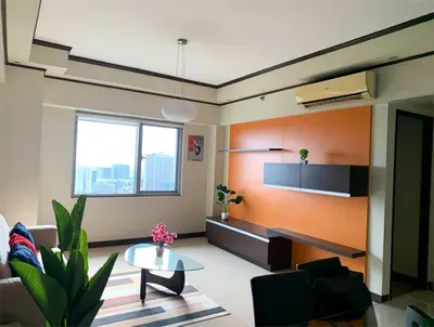 a living room with an orange wall at 2 Bedroom at The infinity Condominium at BGC in Manila