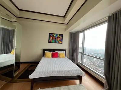 a bedroom with a bed and a large window at 2 Bedroom at The infinity Condominium at BGC in Manila