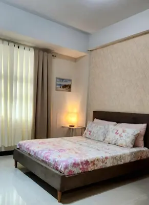 a bedroom with a bed and a lamp on a table at House of B&Y 101 newport blvd across treminal3 in Manila