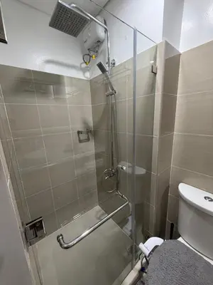 a shower with a glass door in a bathroom at Premium Studio at Shore Residences in Sampong