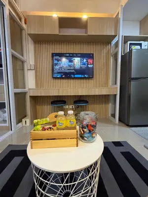 a room with a table with food and a tv at Premium Studio at Shore Residences in Sampong