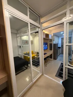 a room with sliding glass doors leading into a living room at Premium Studio at Shore Residences in Sampong