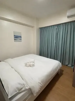 a bedroom with a bed with two towels on it at Sunnyplace Residences 2 BR Near NAIA Airport in Manila