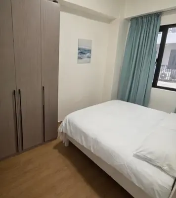 a bedroom with a bed and a cabinet and a window at Sunnyplace Residences 2 BR Near NAIA Airport in Manila