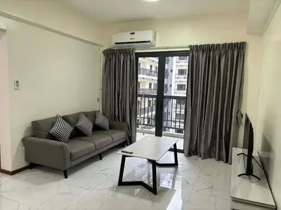 a living room with a couch and a large window at Sunnyplace Residences 2 BR Near NAIA Airport in Manila