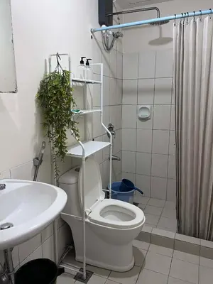 a bathroom with a toilet and a sink and a shower at Casa Feliz Staycation in Manila