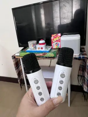 a person holding two remote controls in front of a table at Casa Feliz Staycation in Manila