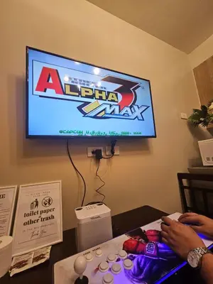 a person sitting at a table in front of a tv at Amenity Pool View 1 BR balcony MOA SMX Ikea Shore002 in Manila