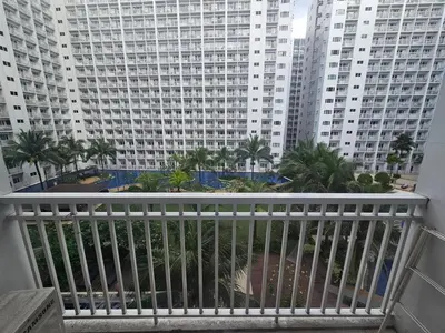 a balcony with a view of a large building at Amenity Pool View 1 BR balcony MOA SMX Ikea Shore002 in Manila